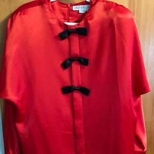 Elegant red satin blouse with black bow ties.